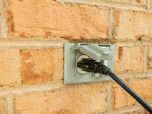 Plugged outlet on a brick wall.