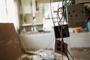 Exposed wires and damaged outlets during Electrical Troubleshooting in a residential renovation.