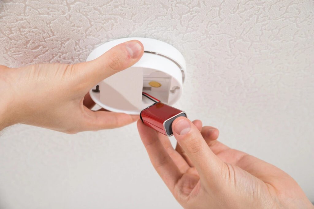 handyman repairing smoke detector
